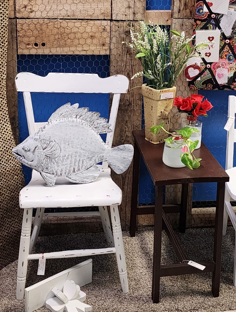 Distressed white chair, large metal fish, small brown table, small distressed shelf and floral arrangements ready for purchase at Antiques & Artisan's, 619 Trolley Rd, Summerville.  These items are for same by GEM Designs, LLC and are located in the room with the large Christmas tree.