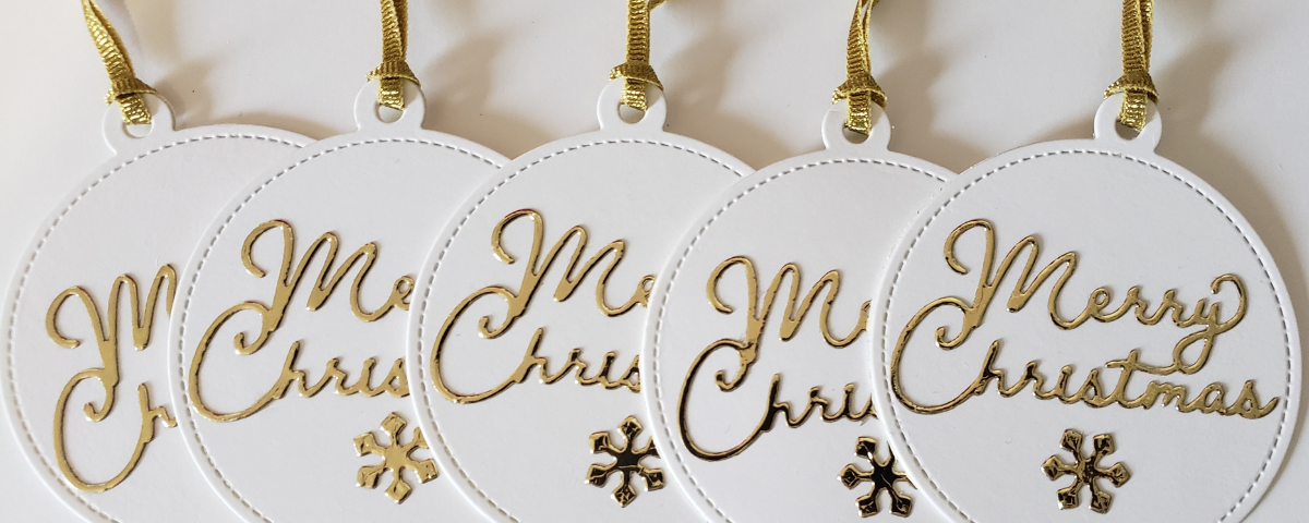 Handmade round gift tag with Merry Christmas in gold accented by a cute gold snowflake.