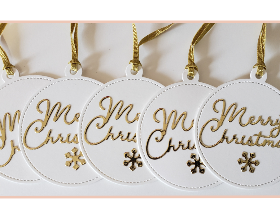 Handmade round gift tag with Merry Christmas in gold accented by a cute gold snowflake.