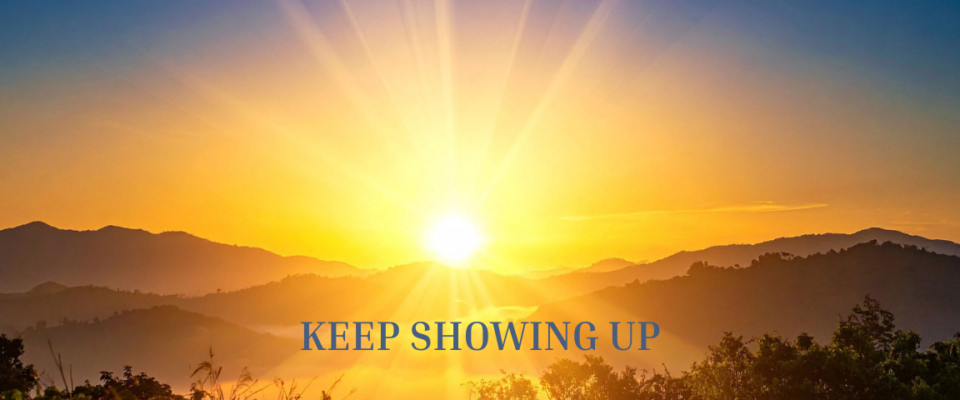 A picture of a sunrise with the words Keep Showing Up on it. nspirational image representing the power of showing up consistently and making progress through daily effort.