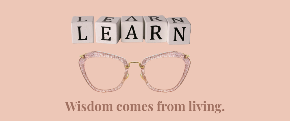Wooden letter blocks spelling LEARN above stylish reading glasses with the phrase "Wisdom comes from living," symbolizing life experience, growth, and personal wisdom.