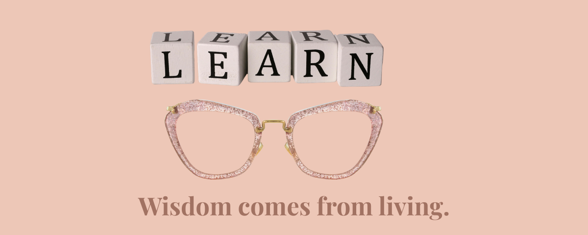 Wooden letter blocks spelling LEARN above stylish reading glasses with the phrase "Wisdom comes from living," symbolizing life experience, growth, and personal wisdom.