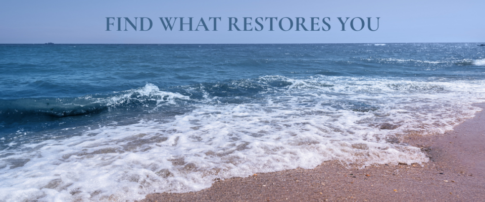 Ocean waves gently rolling onto a sandy beach beneath the words "Find What Restores You," representing peace, restoration, intentional living, and self-care.